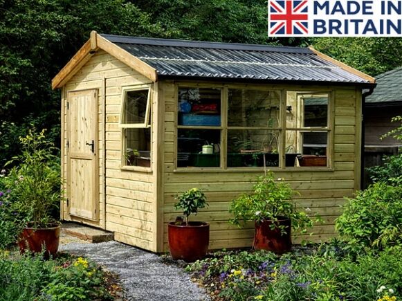 Platinum Alresford Shed 1 A wooden garden potting shed with a green roof and plants around it. The shed has a door and windows.