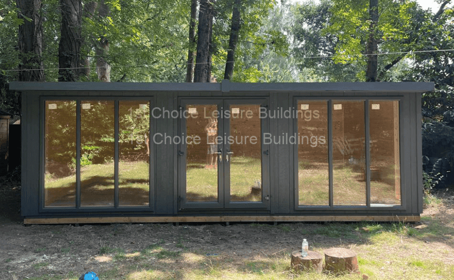 an outdoor garden room with a forest in the background
