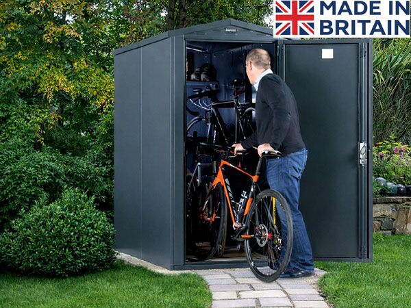 Man placing a bike in a storage shed. The shed provides secure outdoor storage for bicycles.