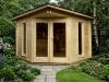 Wooden corner log cabin with sloping roof, patio, double doors, and large side windows in modern minimalist light wood design. Image shown may include non-standard options. A corner log cabin with double doors and large windows on either side, made of interlocking logs.