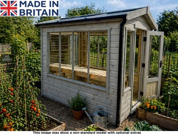 Platinum Herriard Greenhouse 1 A garden room with glass windows and doors, surrounded by plants and flowers.